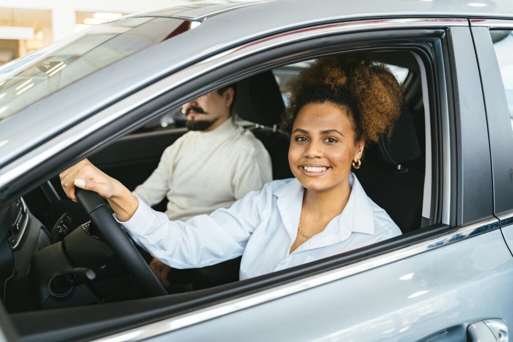 conductrice souriante effectuant un essai routier lors d'une inspection pré achat automobile